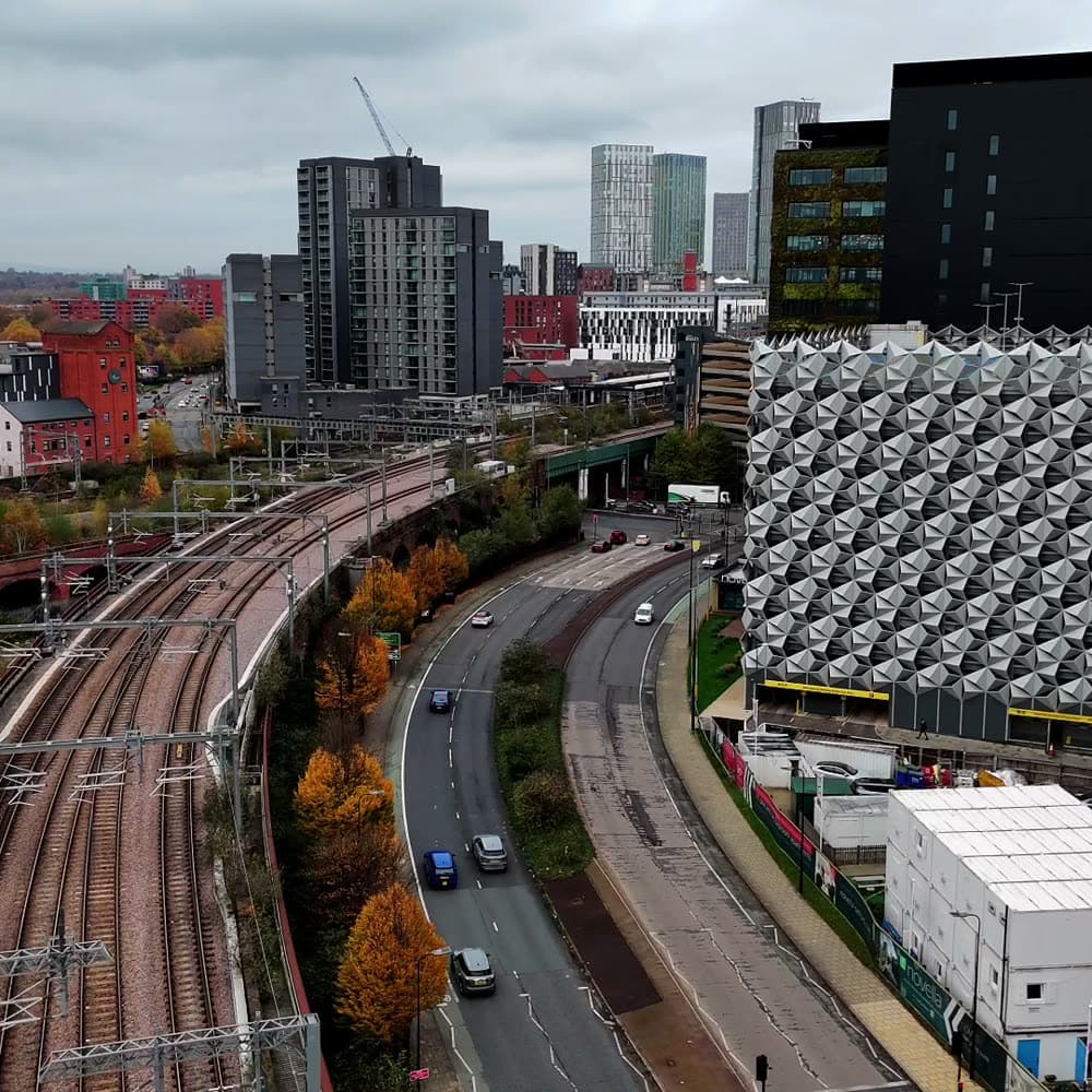 Aerial view along a railway line into Manchester city centre